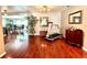Open-concept living room with hardwood floors, an exercise machine and views into the dining area at 3447 Paloma Dr, Holiday, FL 34690