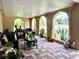 Inviting covered patio featuring brick flooring, comfortable wicker furniture and lush potted plants at 3447 Paloma Dr, Holiday, FL 34690