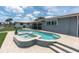 Backyard featuring a sparkling swimming pool, spa, and a well-maintained patio area at 3701 Corsair Ct, New Port Richey, FL 34652