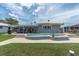 Spacious backyard showcasing a pristine swimming pool, lush lawn, and inviting patio area at 3701 Corsair Ct, New Port Richey, FL 34652