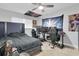 Well-lit bedroom with gaming setup, neutral paint, ceiling fan, and plenty of space at 3701 Corsair Ct, New Port Richey, FL 34652