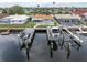 View of dock with boat lift leading up to a waterfront home with backyard pool at 3701 Corsair Ct, New Port Richey, FL 34652