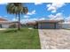 Single-story home with a well-manicured lawn, paver driveway, and a two-car garage at 3701 Corsair Ct, New Port Richey, FL 34652