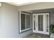 Front entrance featuring a decorative storm door, sidelight window and gray exterior paint at 3701 Corsair Ct, New Port Richey, FL 34652