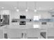 Bright, all-white kitchen with a large island, pendant lighting, and stainless-steel appliances at 3701 Corsair Ct, New Port Richey, FL 34652