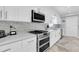 Close up of a modern kitchen with stainless steel appliances and sleek white cabinetry at 3701 Corsair Ct, New Port Richey, FL 34652