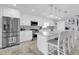 Modern white kitchen with stainless steel appliances, island with seating, and stylish backsplash at 3701 Corsair Ct, New Port Richey, FL 34652