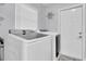Clean laundry room with modern washer and dryer units and an exterior door at 3701 Corsair Ct, New Port Richey, FL 34652