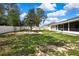 Well-maintained backyard features a fire pit area, mature trees, and a white privacy fence at 4360 Talco Ave, Spring Hill, FL 34609