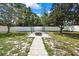Picturesque backyard with a brick fire pit, privacy fence and mature trees at 4360 Talco Ave, Spring Hill, FL 34609