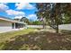 Large backyard featuring green space, mature tree, fire pit, and white vinyl privacy fence at 4360 Talco Ave, Spring Hill, FL 34609