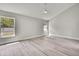 Bright bedroom with gray walls, wood floors, and large windows overlooking the yard at 4360 Talco Ave, Spring Hill, FL 34609