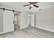 Bedroom featuring modern gray floors and barn doors to hallway and closet at 4360 Talco Ave, Spring Hill, FL 34609