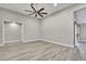 Spacious bedroom with modern ceiling fan and gray wood-look flooring and white baseboards at 4360 Talco Ave, Spring Hill, FL 34609
