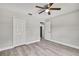 This bedroom features gray walls, wood-look floors, ceiling fan, and double door closet at 4360 Talco Ave, Spring Hill, FL 34609