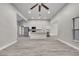 Open-concept living room with adjacent kitchen and gray wood-look floors at 4360 Talco Ave, Spring Hill, FL 34609