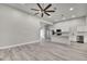 Open-concept living room with adjacent kitchen and gray wood-look floors at 4360 Talco Ave, Spring Hill, FL 34609