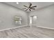 Spacious living room featuring light gray walls, light wood-look floors, a large window, and high ceilings at 4360 Talco Ave, Spring Hill, FL 34609