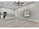 Open-concept living room with adjacent kitchen and gray wood-look floors at 4360 Talco Ave, Spring Hill, FL 34609