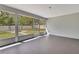 Spacious screened porch with a view of the fenced backyard and fire pit area at 4360 Talco Ave, Spring Hill, FL 34609