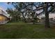 Lush backyard with mature trees and waterfront views, perfect for outdoor activities and relaxation at 4439 Reeves Rd, New Port Richey, FL 34652