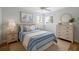 Cozy bedroom with soft lighting, striped bedding, light wood furnishings, and a serene, inviting atmosphere at 4439 Reeves Rd, New Port Richey, FL 34652