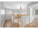 Upstairs hallway features wood floors, wood banister, and classic lighting at 4439 Reeves Rd, New Port Richey, FL 34652