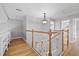 Upstairs hallway with wood floors, wood and white banister and plenty of natural light at 4439 Reeves Rd, New Port Richey, FL 34652