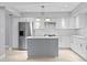 Bright white kitchen featuring stainless steel appliances and a gray center island at 4439 Reeves Rd, New Port Richey, FL 34652