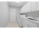 Bright laundry room with ample storage, modern washer and dryer, and a sink at 4439 Reeves Rd, New Port Richey, FL 34652