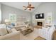 Comfortable living room features a fireplace, fan, and bright windows at 4439 Reeves Rd, New Port Richey, FL 34652