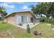 Back of the house featuring a small patio with plenty of sunlight and a green yard at 4543 Dewey Dr, New Port Richey, FL 34652