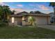 Attractive single-story home with a two-car garage and manicured landscaping at dusk at 4543 Dewey Dr, New Port Richey, FL 34652