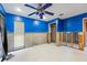 Bright living room featuring tiled floors, ceiling fan, and partially renovated walls at 4543 Dewey Dr, New Port Richey, FL 34652