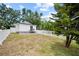 View of charming back house with a white picket fence and a small wooden porch under a cloudy blue sky at 4622 Paloverde Dr, New Port Richey, FL 34652