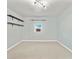 Neutral bedroom featuring two floating shelves, a window unit, and carpet flooring at 4622 Paloverde Dr, New Port Richey, FL 34652