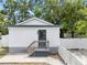 The exterior of the back house has white siding, a dark gray trim, small porch, with white picket fences on both sides at 4622 Paloverde Dr, New Port Richey, FL 34652