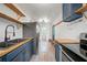 Galley kitchen featuring butcher block countertops, stainless steel appliances, blue cabinets, and floating shelves at 4622 Paloverde Dr, New Port Richey, FL 34652