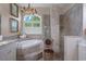 Bathroom exhibiting a glass shower, a jacuzzi tub, and double sink vanity with marble countertop at 5072 Abbonmarsh Cir, Brooksville, FL 34604