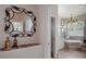 A hallway leading to a refined bathroom featuring a soaking tub and vanity with designer mirror at 5072 Abbonmarsh Cir, Brooksville, FL 34604