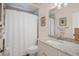 Bright bathroom featuring a granite countertop, large mirror, and tiled shower with shower curtain at 5072 Abbonmarsh Cir, Brooksville, FL 34604