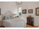 Bright bedroom with a light fixture, wood floors, a colorful glass window and decor at 5072 Abbonmarsh Cir, Brooksville, FL 34604