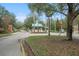 Community entrance with a guard house, manicured landscaping and mature trees at 5072 Abbonmarsh Cir, Brooksville, FL 34604
