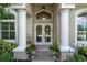 Close-up of the front entrance showcasing double doors with decorative wreaths and adjacent sidelight windows at 5072 Abbonmarsh Cir, Brooksville, FL 34604