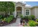 Inviting entryway featuring a double-door entry framed by columns and beautiful landscaping at 5072 Abbonmarsh Cir, Brooksville, FL 34604