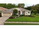 Charming single story home with a manicured lawn, beautiful landscaping, and a two-car garage at 5072 Abbonmarsh Cir, Brooksville, FL 34604