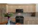 Kitchen featuring wooden cabinets, granite countertops, and stainless steel stove and microwave at 5072 Abbonmarsh Cir, Brooksville, FL 34604