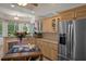 Bright kitchen featuring natural wood cabinetry, granite countertops, stainless steel appliances, and a bay window at 5072 Abbonmarsh Cir, Brooksville, FL 34604