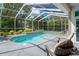 Relaxing screened-in pool and spa with lush landscaping and outdoor seating at 5072 Abbonmarsh Cir, Brooksville, FL 34604