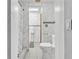 Bathroom featuring a shower, toilet, and tile flooring; the walls are decorated with attractive marble tile at 5543 Moog Rd, New Port Richey, FL 34652